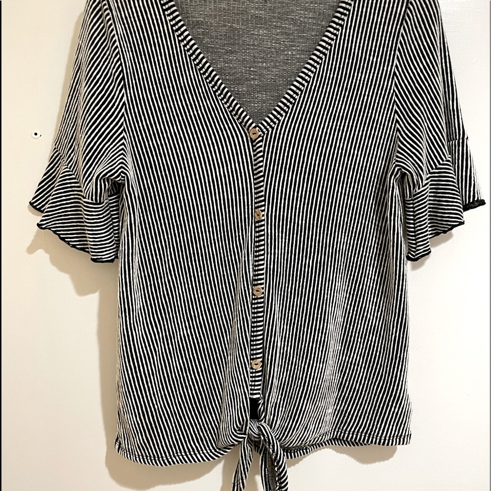 Cute black and white striped shirt with ruffles on the sleeves. Size Medium.